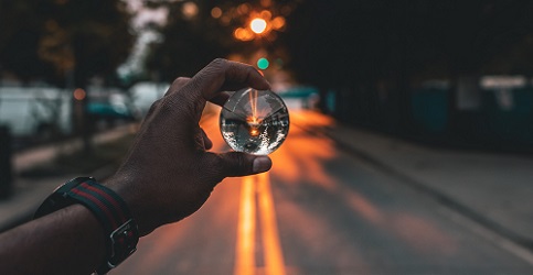 A person holding a glass orb