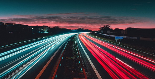 Long exposure of cars speeding down a freeway at dusk